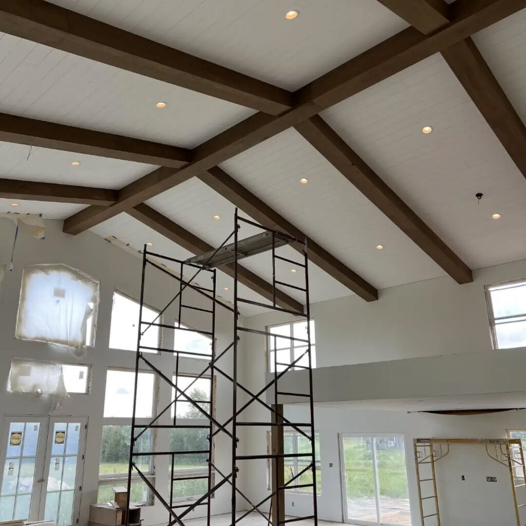 Custom box beams in a ridge-and-rafter layout on a vaulted wood ceiling