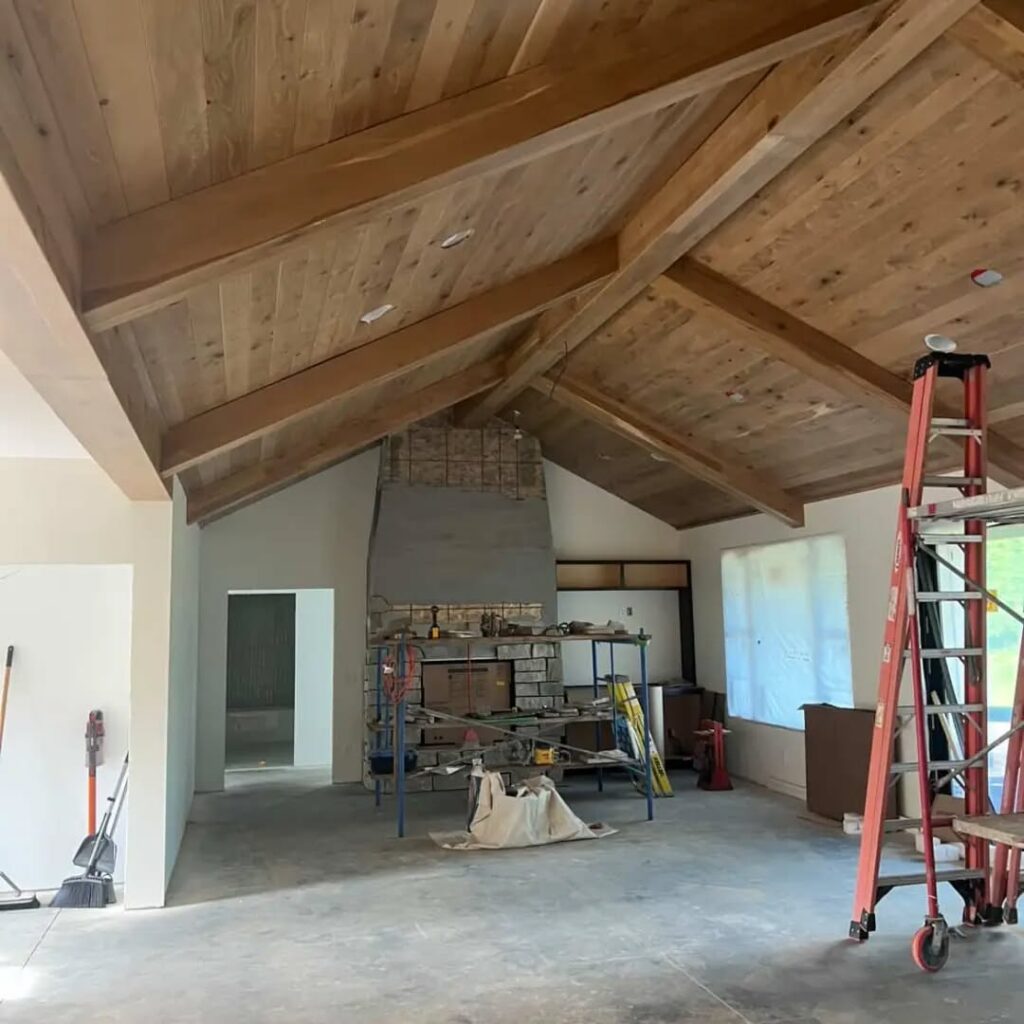 Custom wood box beams with tongue-and-groove paneling in an open living room